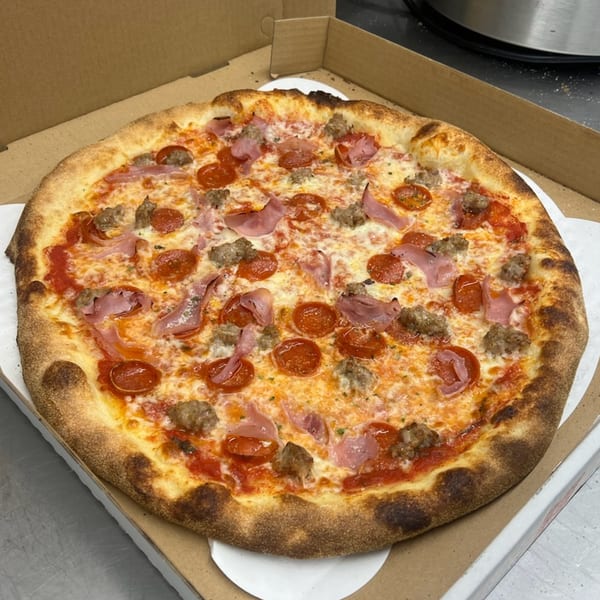 Mia Ava East Coast Pizza's meat lover's pizza with pepperoni, ham, and sausage in a box.