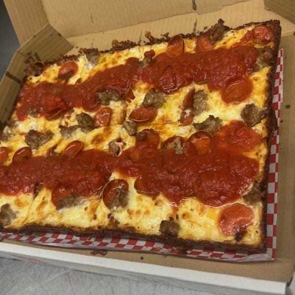 Mia Ava East Coast Pizza's square deep-dish pizza with pepperoni, sausage, and red sauce stripes.