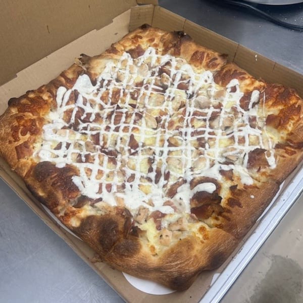 Mia Ava East Coast Pizza's square white pizza with chicken and a white sauce drizzle in a box.